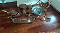 Overview of the copper cookware set showing multiple copper pots, pans, bowls, some lids and a warming pan.