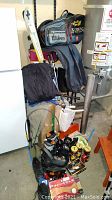 Photo showing golf balls, tennis balls, ski boots, goggles, hip waders, tennis rackets bag, helmets and boots arranged together