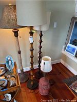 Five lamps arranged together showing varied styles and bases including woven, wood, ceramic