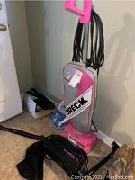 Oreck XL upright vacuum with cloth bag and canister vacuum on floor with cord wrapped on handle.