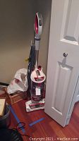 Full view of upright Shark Rotator vacuum cleaner with cord wrapped around handles.