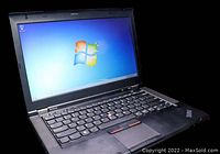 Front view of Lenovo ThinkPad T430 laptop powered on showing Windows 7 desktop.
