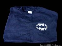 Folded dark blue Batman T-shirt showing classic Batman logo on chest