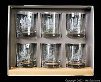 Set of six clear glass tumblers in original box with etched sailing ship design on each glass.