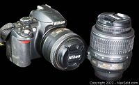 Photo showing Nikon D3100 camera body with 35mm lens attached and separate 18-55mm lens