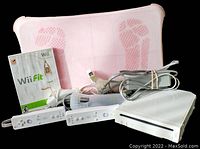 Photo showing all included items: Wii console, two remotes, balance board with footprints, Wii Fit game DVD, and cables.