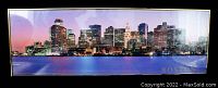 Full view of framed panoramic Boston cityscape at dusk with purple and pink sky reflected on water, showing city buildings and word 'BOSTON' in corner.