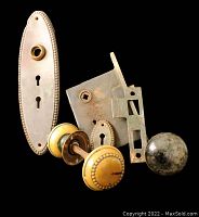 Vintage door hardware set on black background showing all items included in the lot.