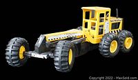 Front angled view of the vintage Tonka steel road grader showing the yellow cab, black frame and front wheels.