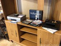 Panasonic VCR, Sony DVD player, assorted DVDs displayed on a wood cabinet including Tonight Show Johnny Carson Collection, Mountain Men, Duck Dynasty