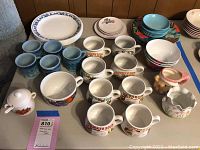 Overview of all dinnerware items including mugs, plates, pitcher, and vase on a table