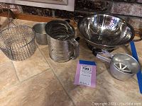 Photo showing entire lot including frying basket, three sifters, colander, and small strainer.
