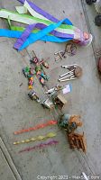 Overview of the lot showing wind sock, various wind chimes, and colorful fish figurines on ground