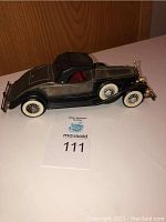 Side view of the 1931 Rolls Royce model car showing detail and size with auction lot card.