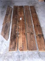 Four long barn boards placed on concrete floor, showing length and width of boards.