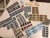 Wide view of various sheets and blocks of Canadian stamps laid out on white table