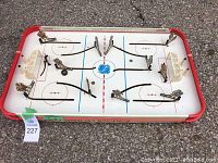 Full view of the vintage tabletop hockey game showing player rods and puck on rink surface.