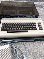 Commodore 64 computer keyboard unit atop Game Organizer, power adapter and cables visible