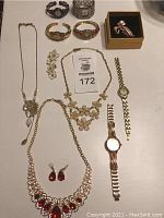 Full overhead view of all items: necklaces, earrings, brooch, bangles, and 6 watches.