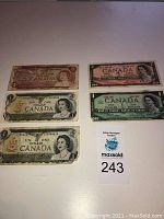 Five older Canadian banknotes arranged in two columns showing varied color and design; includes $1 and $2 denominations.