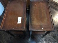 Top view of two wooden end tables side by side on hardwood floor showing surface wear and scratches.