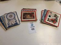 Several stacks of vintage Christmas cards showing different designs including fireplace scene, holly with bells, and various winter scenes.