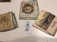 Photo showing stacks of vintage Christmas cards and postcards grouped on a white surface.