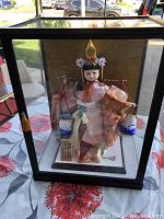 Full view of the vintage Japanese female doll inside a glass case, showing overall presentation.