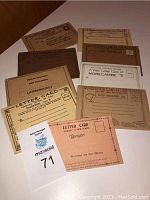 Nine vintage photograph postcard folders arranged on a flat surface showing various titles and locations.