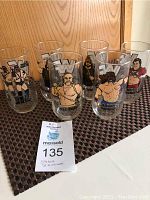 Full view of six WWF drinking glasses arranged in line, showing colorful wrestler portraits and WWF logo
