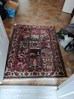 Full view of rectangular rug showing overall pattern and fringe on tiled floor