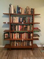 Front view of wood bookcase with five shelves and books