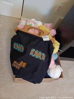 Box of assorted wool yarn balls with black fabric bag with wooden handles on top