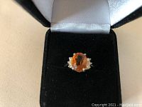 Ring displayed in black velvet box showing top view