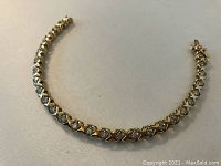 Curved view of bracelet showing diamond settings and gold finish
