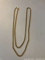 Full view of the yellow gold chain laid out on a light background.