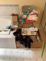 Overview of medical and health supplies on bathtub edge and chair, including boxed items, knee brace, and medical dressings.