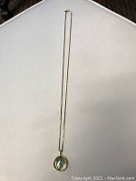 Full-length view of necklace on white background