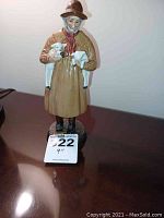 Front view of Royal Doulton figurine 'Lambing Time' showing female figure holding two lambs, 9 inches tall.