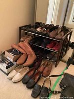 Full display of shoe rack with multiple shelves and floor shoes.