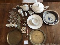 Wide view of all items including ceramic espresso set, Slowilwitz shot glasses, brass trays, tureen, Dansk platter, teapot and cups.