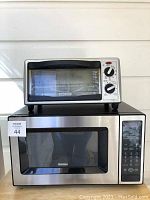 Kenmore microwave and Black & Decker toaster oven stacked, showing exterior condition.