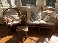 Loveseat and armchair with side table, cushions and throw pillows in sunlit room