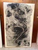 Full view of the signed abstract painting on canvas showing textured black and white design in a wooden frame.