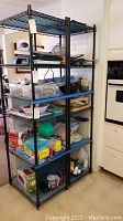 Two black metal wire shelving units filled with household items, demonstrating size and structure