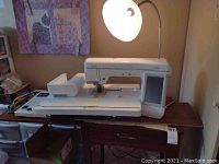 Machine with detachable extension table on wooden table