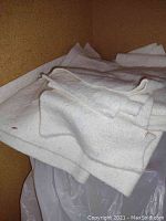 Folded white cotton and other fabric batting pieces stacked inside a cabinet space.