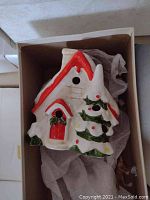 Stonehurst House ceramic holiday house with snow and red roof accents, in original packaging with tissue paper.
