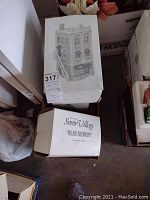 Village Greenhouse building packaging, black and white box with illustration