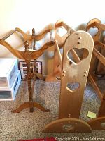 Two wooden quilt racks viewed from the side showing design differences and heart cutouts on one rack